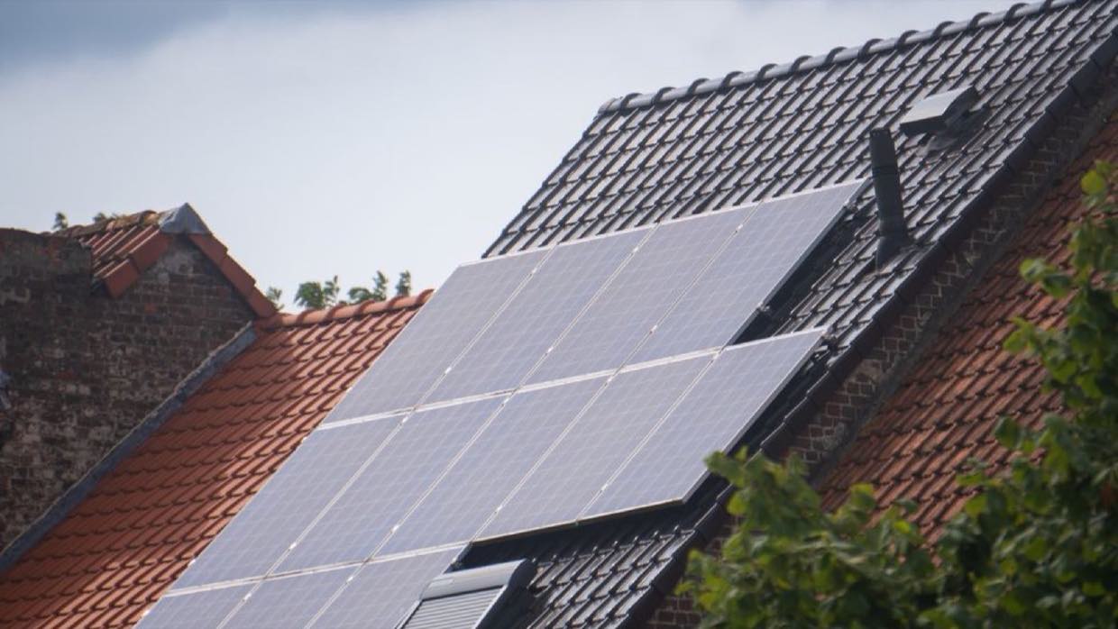 A residential solar array mounted across a tiled pitched roof.